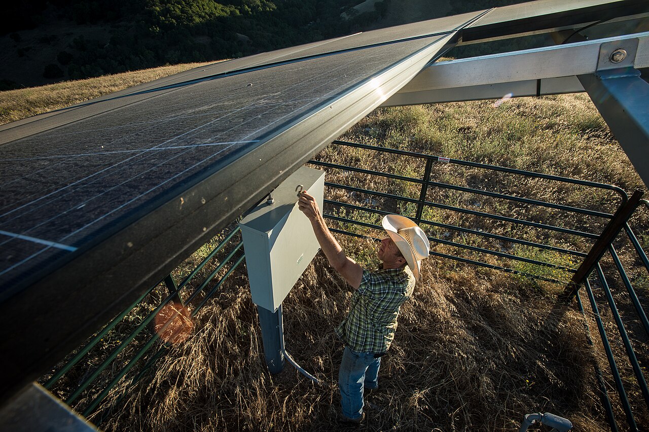 Technician maintaining a solar-powered water pump installation